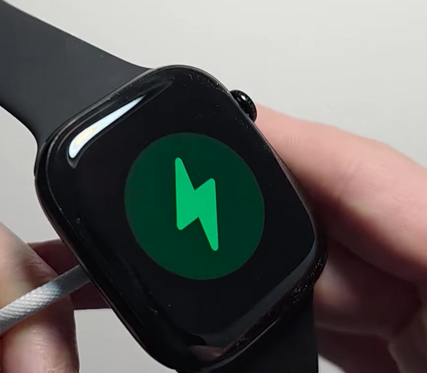 Close-up of an Apple Watch screen showing a green lightning bolt charging symbol