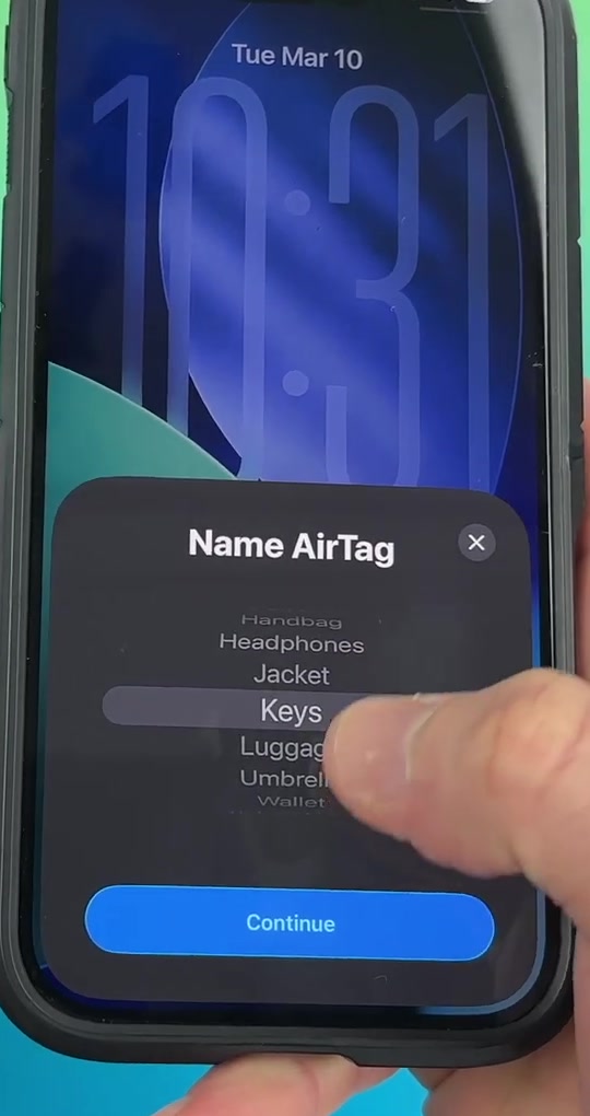 iPhone showing the Name AirTag picker wheel with Keys selected from a list of category names