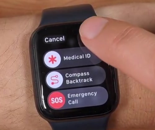 A finger tapping the small power icon at the top right of the Apple Watch sliders screen