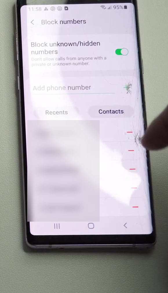The Block numbers screen on a Samsung Galaxy phone, showing the Block unknown hidden numbers toggle and a list of blocked entries each with a red minus icon