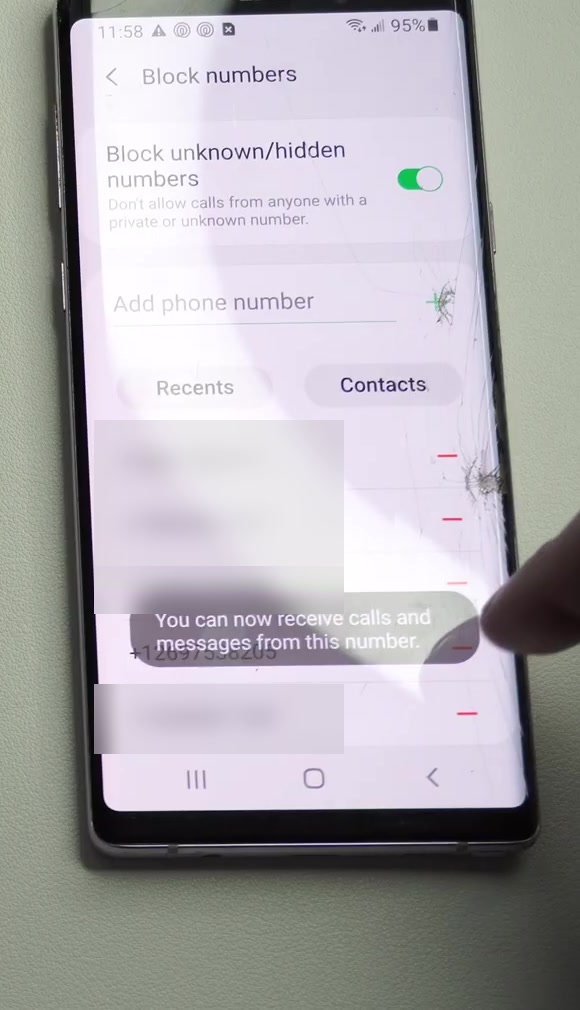 The Samsung Block numbers screen showing a confirmation message reading You can now receive calls and messages from this number