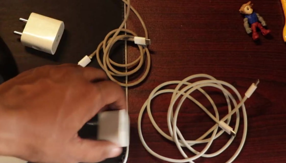 A USB wall adapter and two charging cables laid out on a desk for inspection