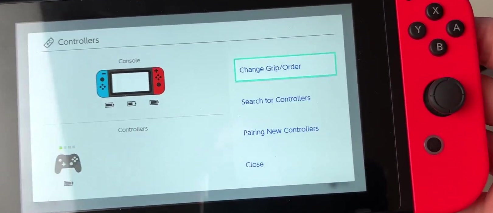 Nintendo Switch Controllers menu with Change Grip/Order highlighted above Search for Controllers and Pairing New Controllers
